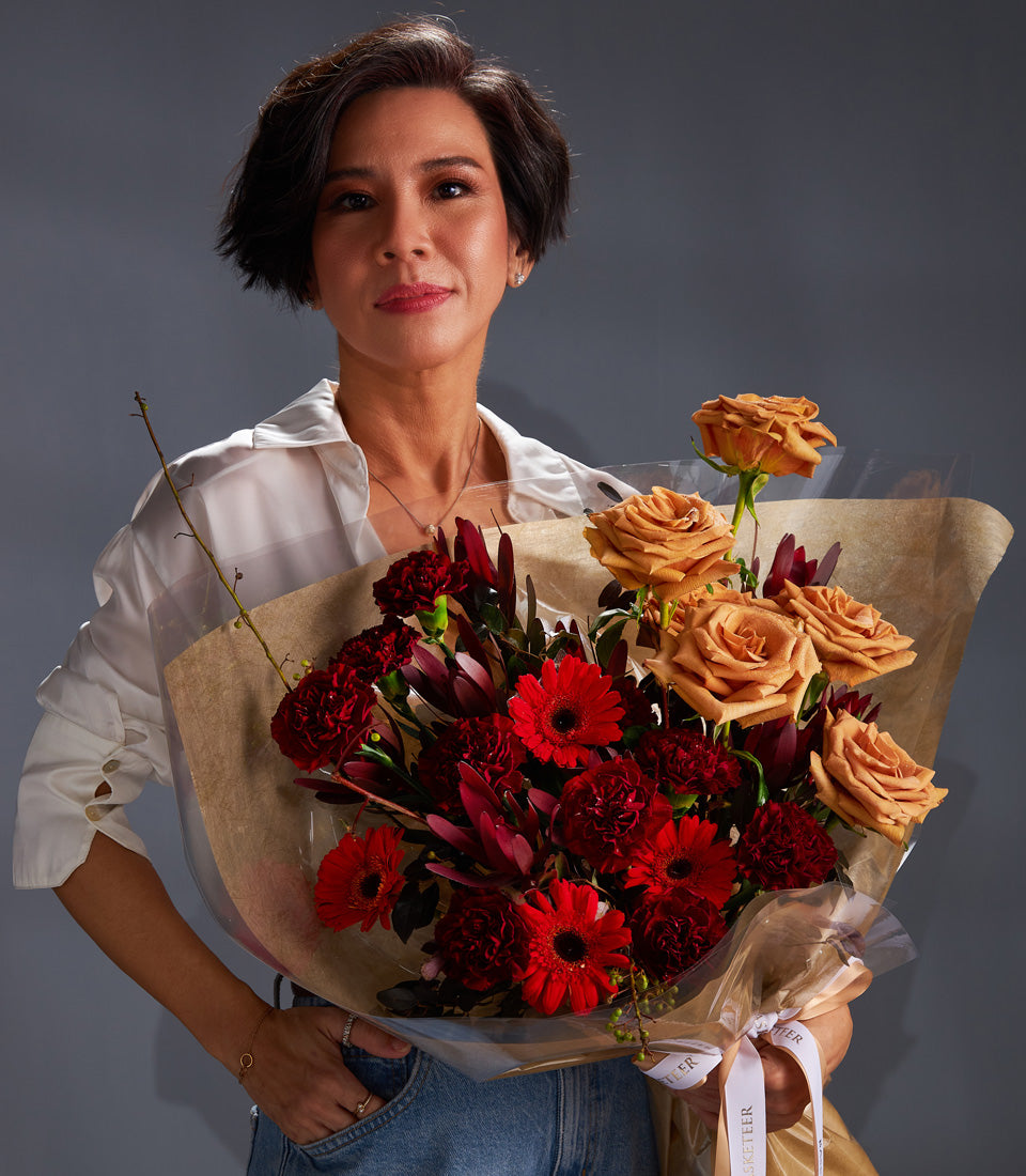 Luxury red and orange rose bouquet with gerbera daisies wrapped in kraft paper, elegant gift arrangement