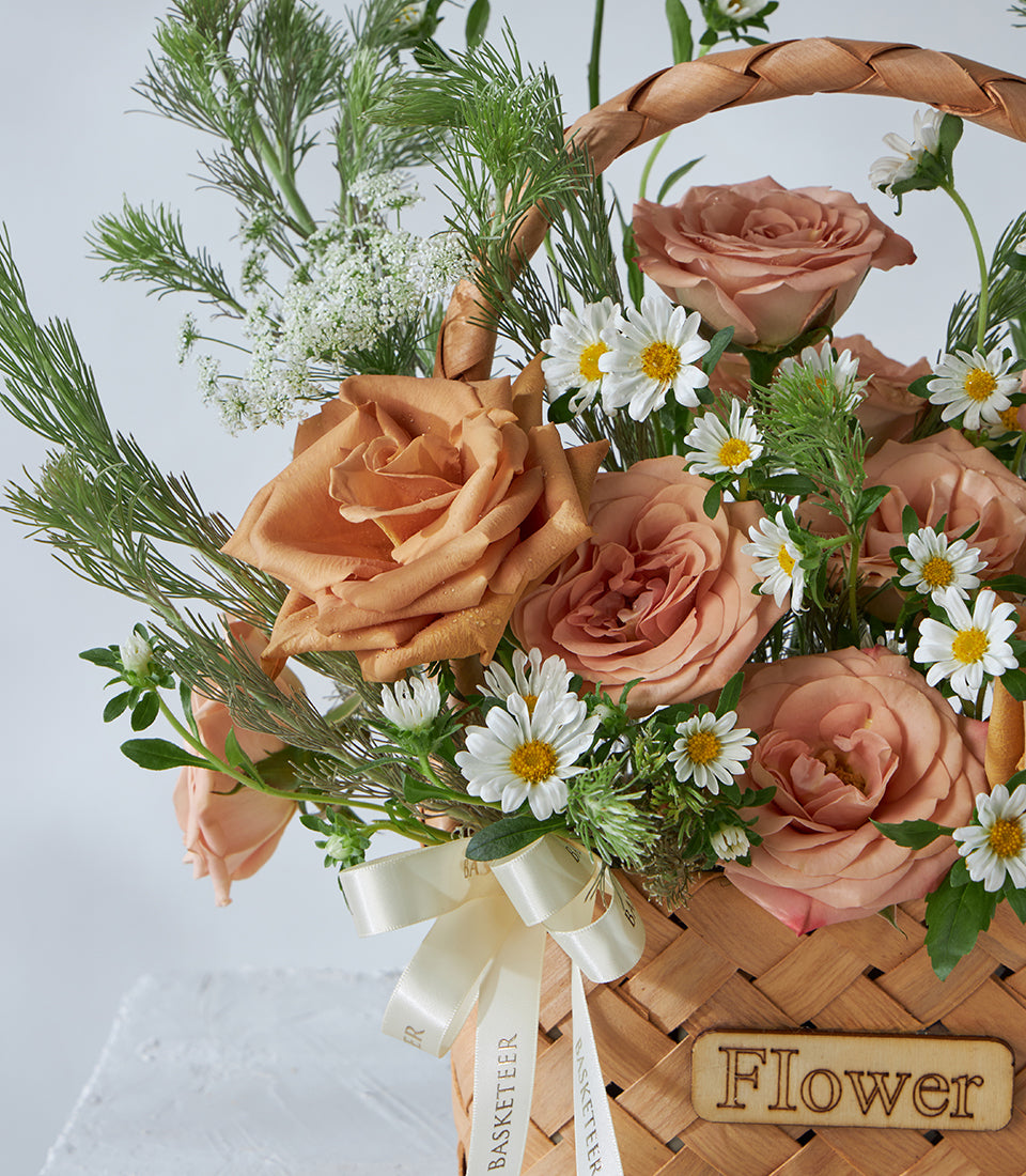Peach rose and white daisy flower basket with woven handle, ideal for birthday gifting