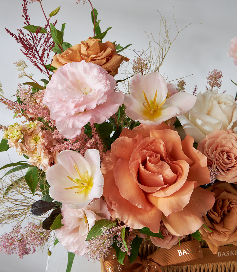 Toffee rose and pink lisianthus arrangement in woven basket with caramel ribbon