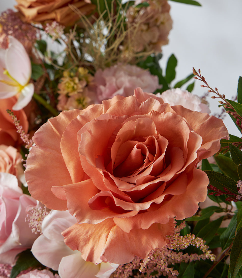Caramel pink rose and lisianthus flower basket with coral gradient blooms and textured greenery