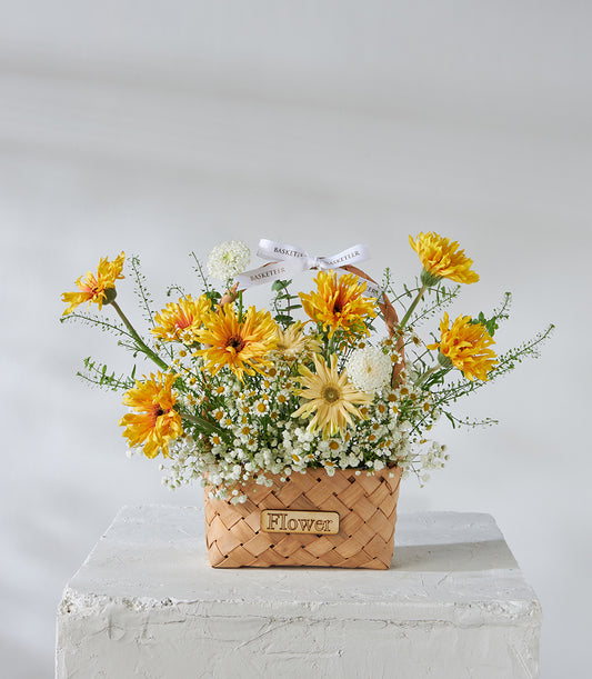 Yellow chrysanthemums and white baby's breath in woven basket, birthday flower gift