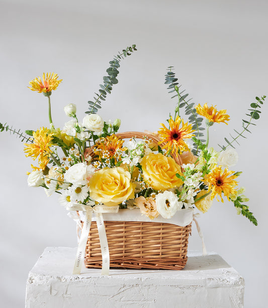 Yellow and white rose basket with eucalyptus greenery and woven wicker for birthday celebrations