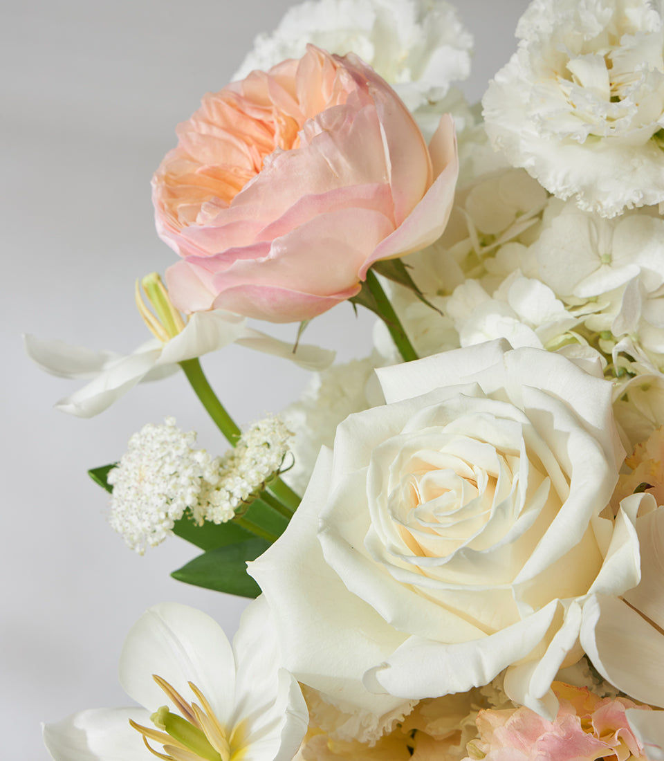 Peach garden roses and white roses in a luxury gift basket arrangement