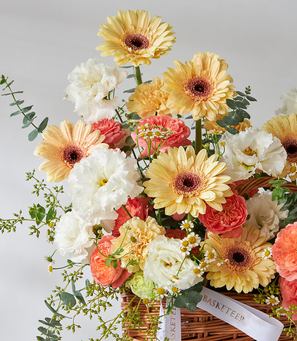 Peach gerbera, white carnation, and yellow daisy basket bouquet with eucalyptus, birthday flowers arrangement