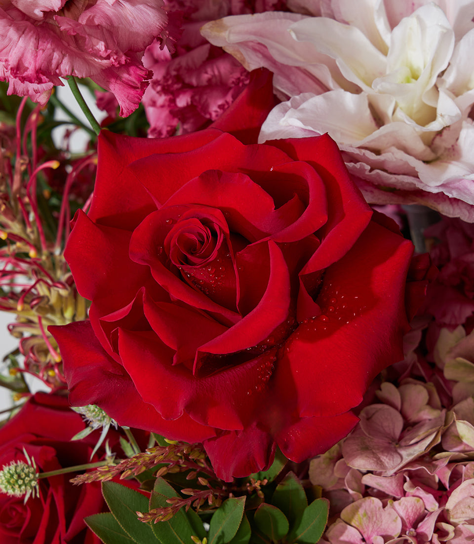 Red roses and pink lilies luxury bouquet in woven basket