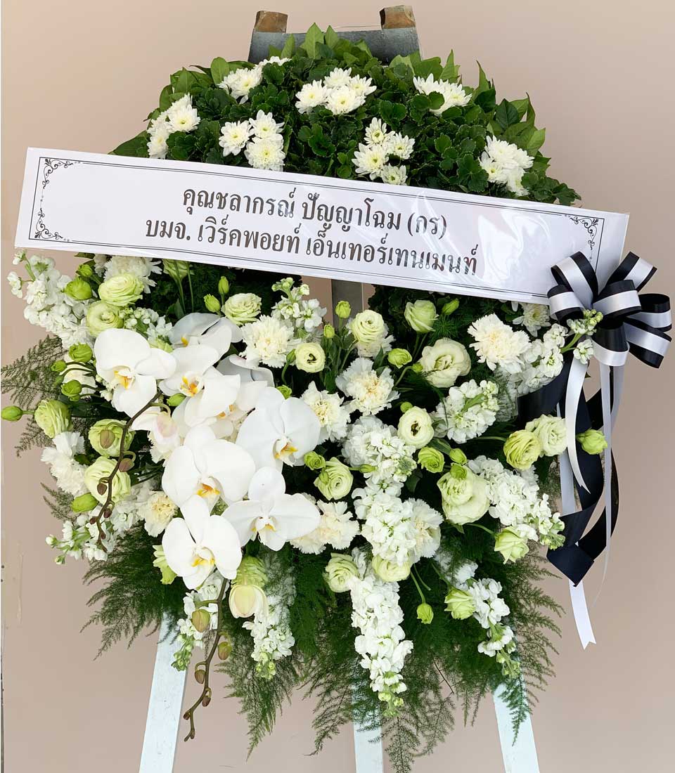 Elegant white orchid and chrysanthemum funeral wreath with green foliage, Thai condolence banner, and black ribbon
