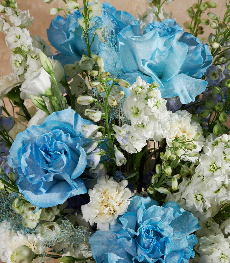 Light blue roses and white flowers in premium vase arrangement, luxury gift from Basketeer