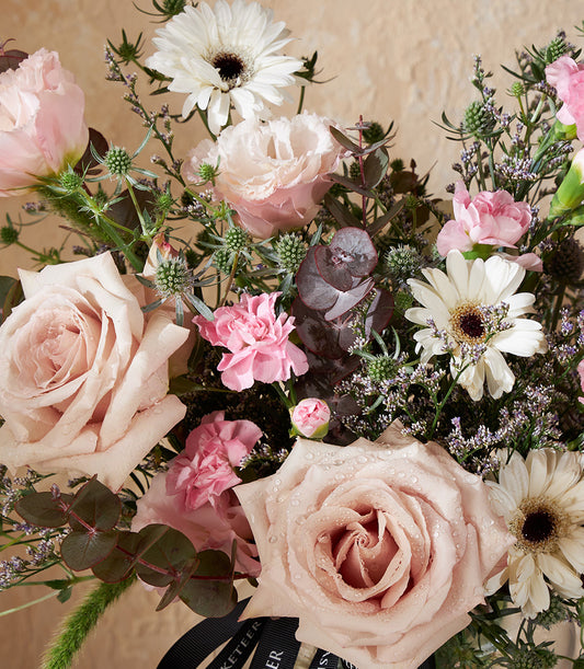 Pink and white rose bouquet with gerbera daisies in elegant vase arrangement