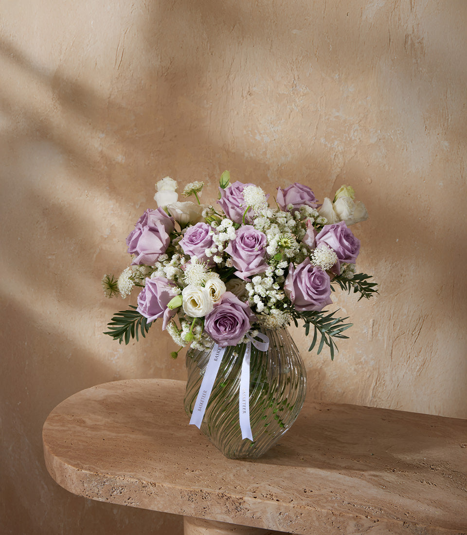 Lavender and white fresh rose vase arrangement with ranunculus and baby's breath