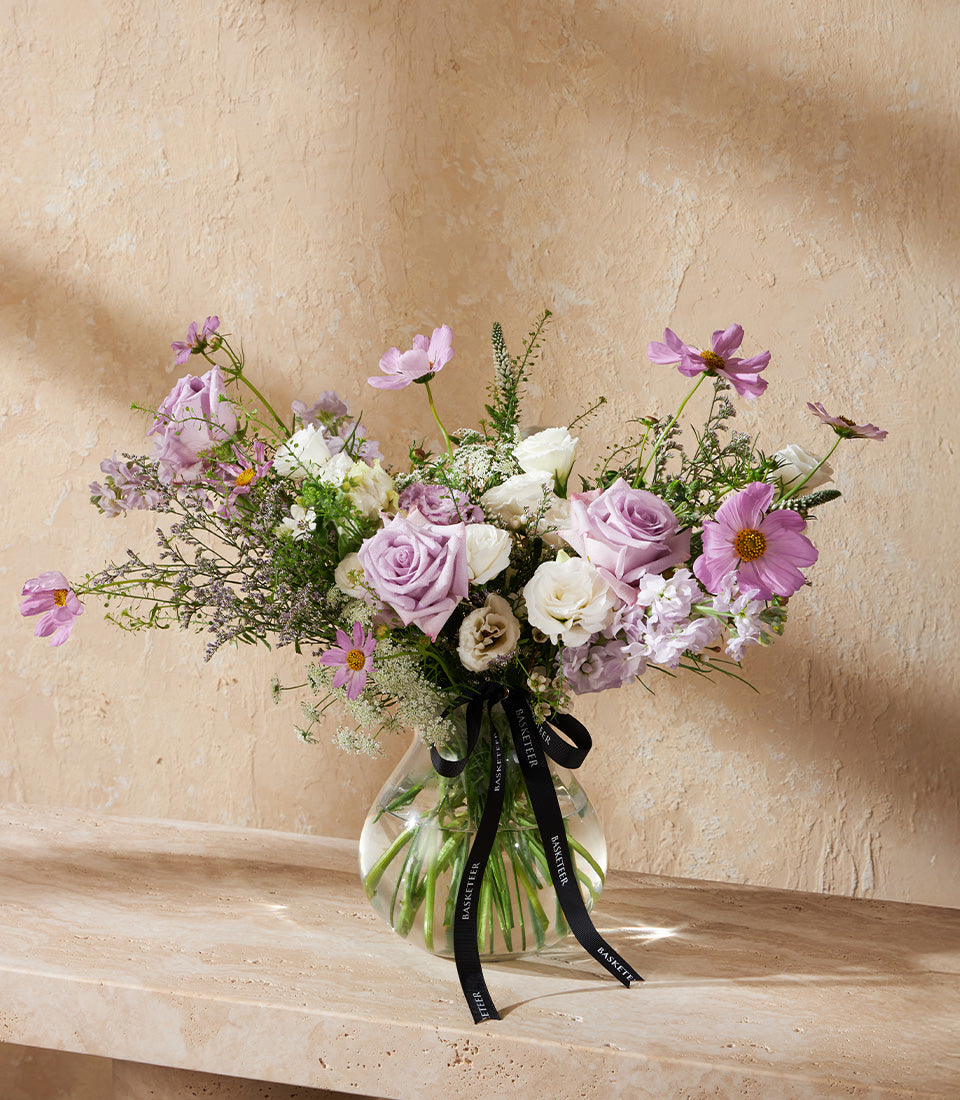 Lavender Elegance purple and pink rose vase arrangement with cosmos and greenery in clear glass