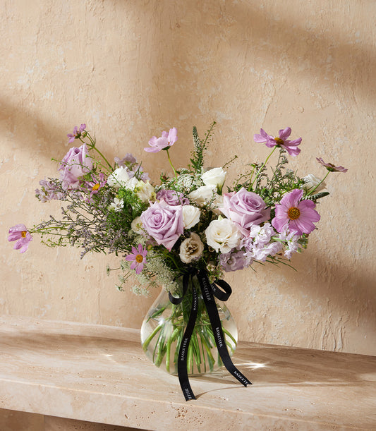 Lavender Elegance purple and pink rose vase arrangement with cosmos and greenery in clear glass