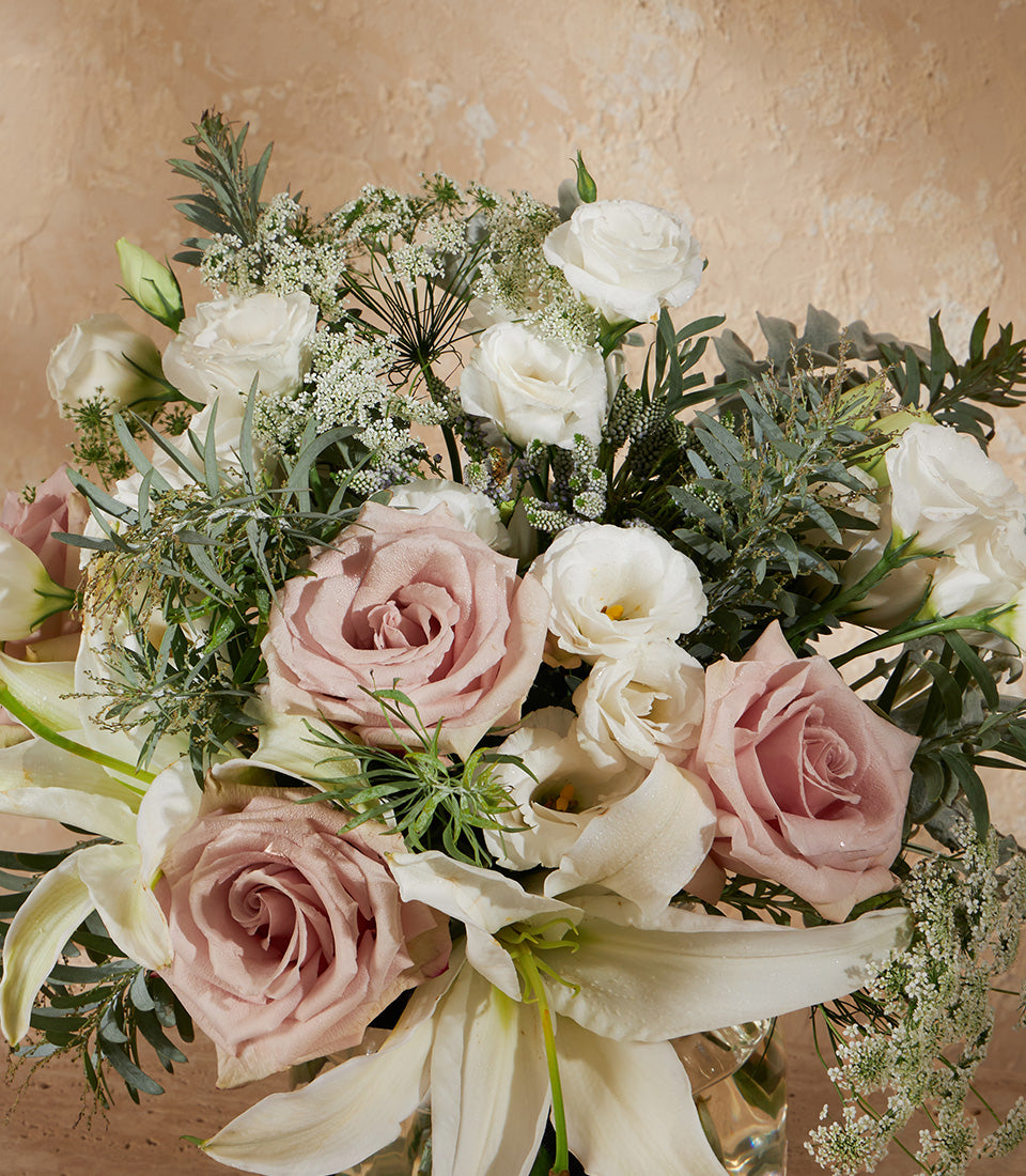 Pale pink roses and white eustoma bouquet with lilies in glass vase