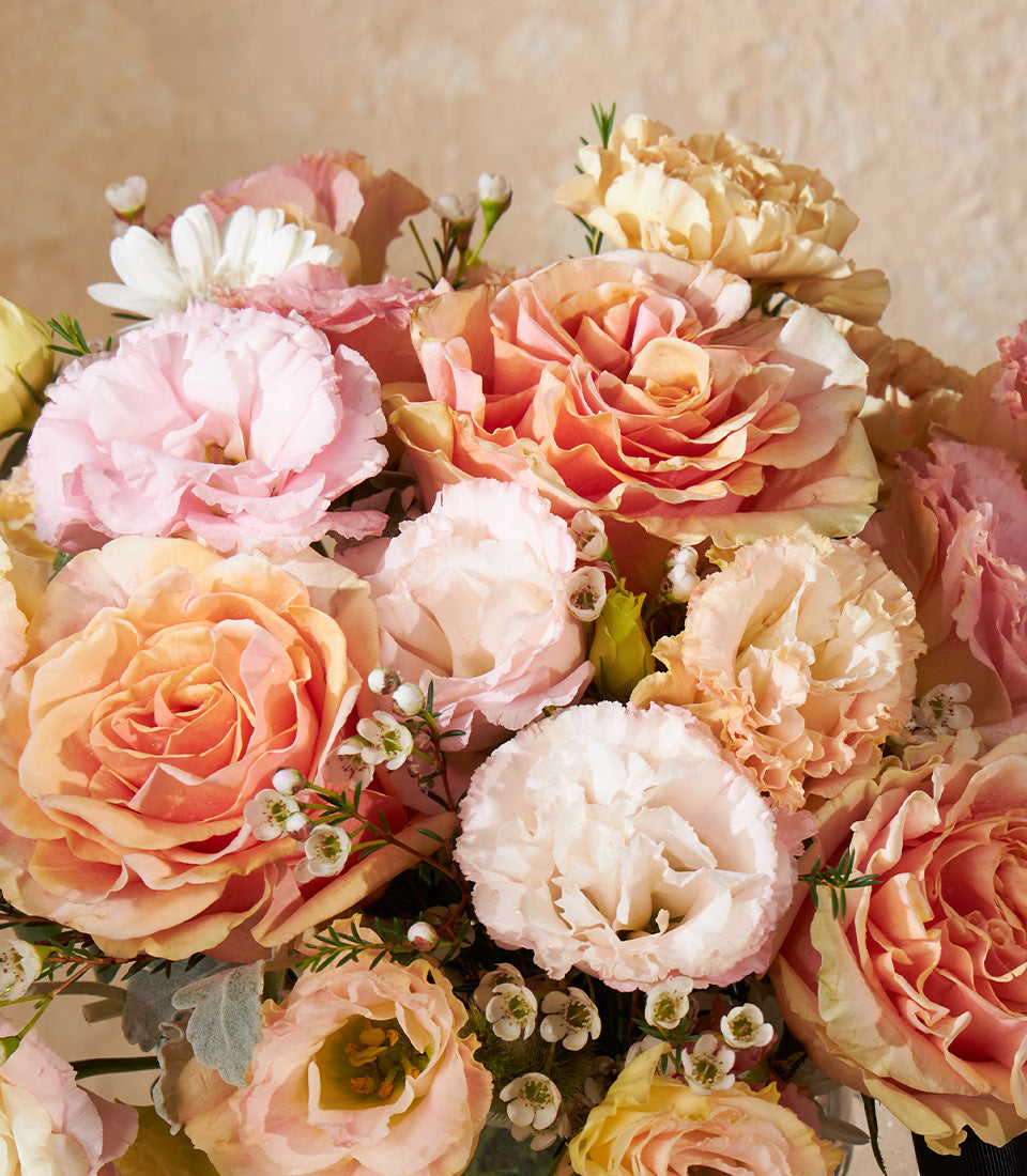 Peach and cream rose vase arrangement with eustoma and filler flowers