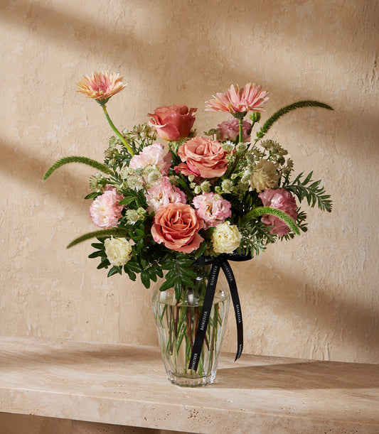 Pink and peach roses with gerberas in clear glass vase, premium fresh flower arrangement