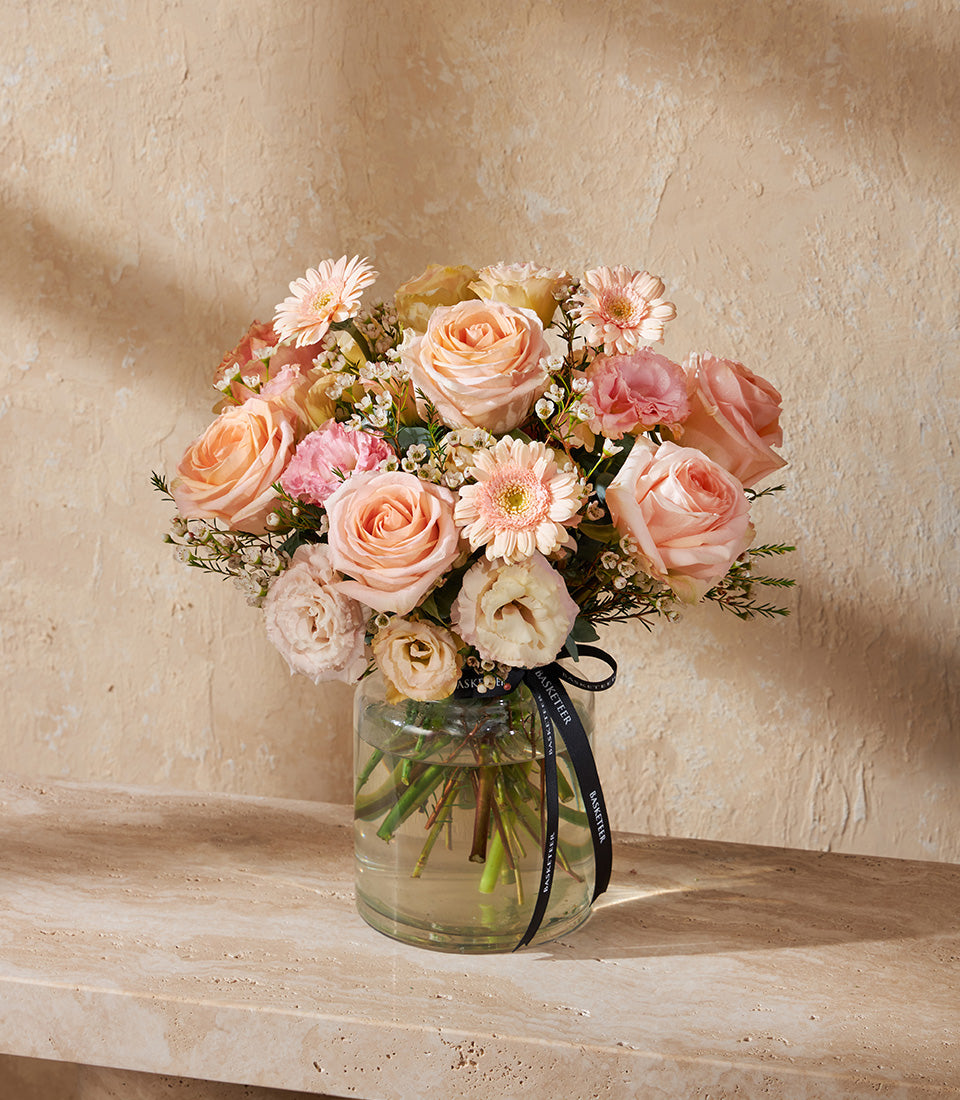 Peach and pink rose bouquet with gerberas in clear glass vase, fresh flower gift arrangement