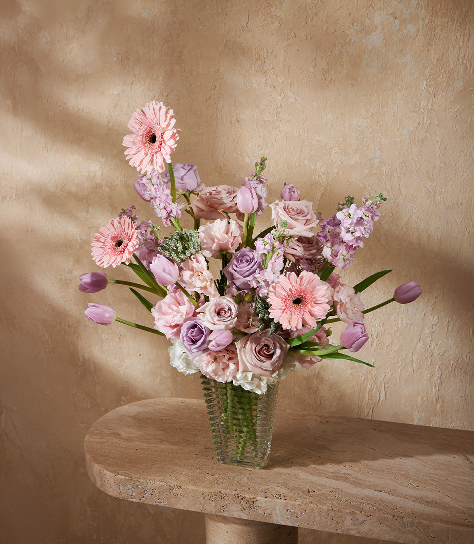 Lavender peach roses and gerbera daisies in clear glass vase, premium fresh flower arrangement