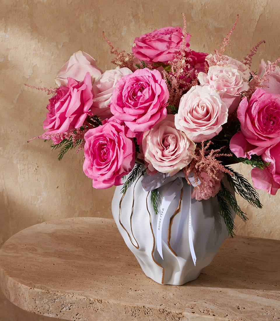 Blush pink rose and astilbe bouquet in textured white ceramic vase with gold accents