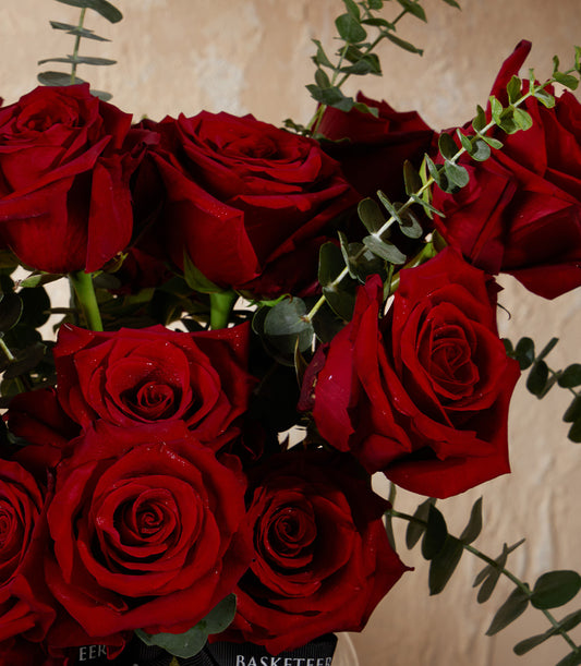Deep red roses with eucalyptus in elegant vase arrangement, premium fresh flowers for gifting