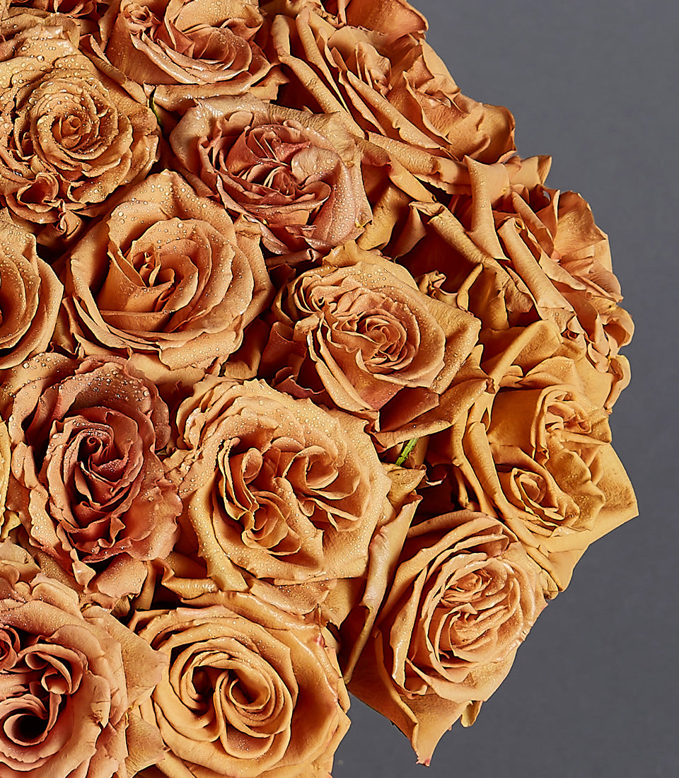 Muted terracotta roses with water droplets in rounded luxury bouquet arrangement