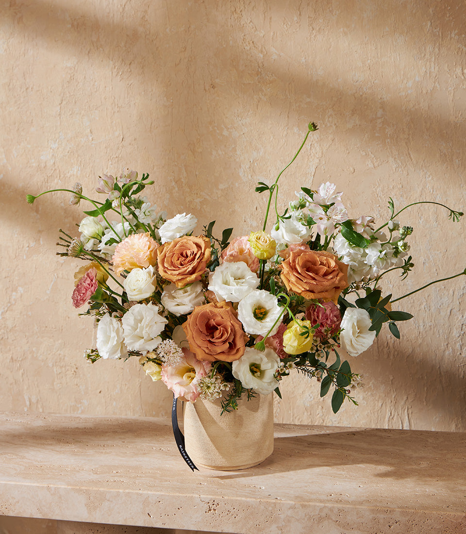 Peach and white rose arrangement in cream ceramic vase, fresh flowers with lisianthus and carnations for gifting