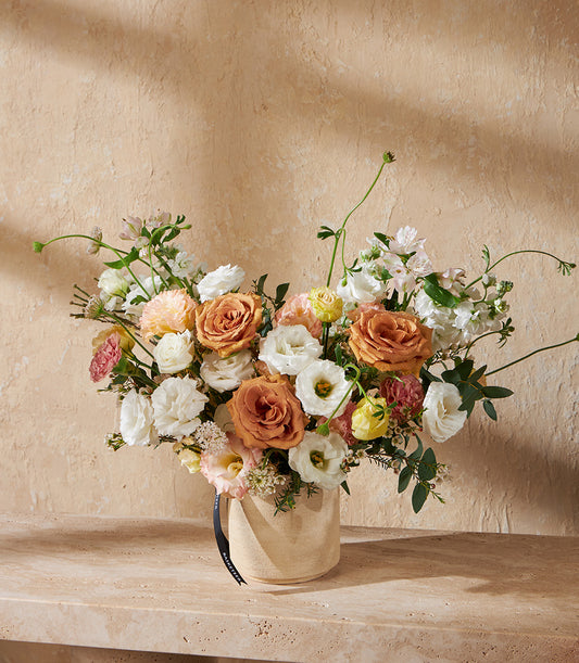 Peach and white rose arrangement in cream ceramic vase, fresh flowers with lisianthus and carnations for gifting