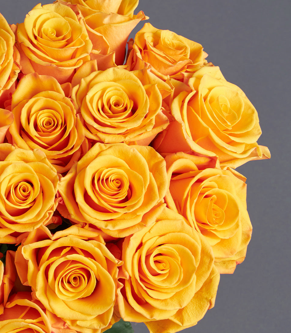 Vibrant orange rose bouquet with warm yellow-toned petals, lush and densely arranged