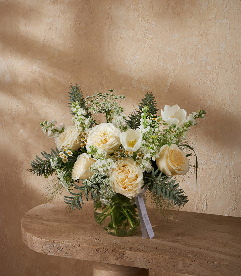 White roses and tulips with eucalyptus in clear glass vase, premium flower arrangement for gifting