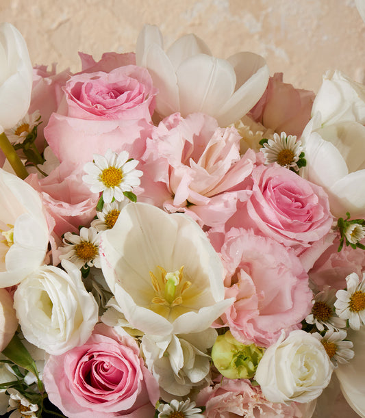 Pastel pink roses, white tulips, and daisies in a lush fresh flower vase arrangement