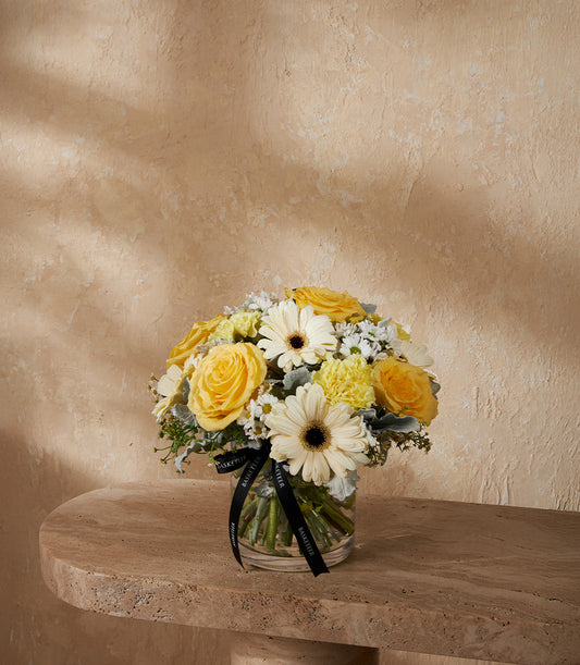 Yellow and white rose arrangement with gerbera daisies in clear glass vase, luxury gift hamper
