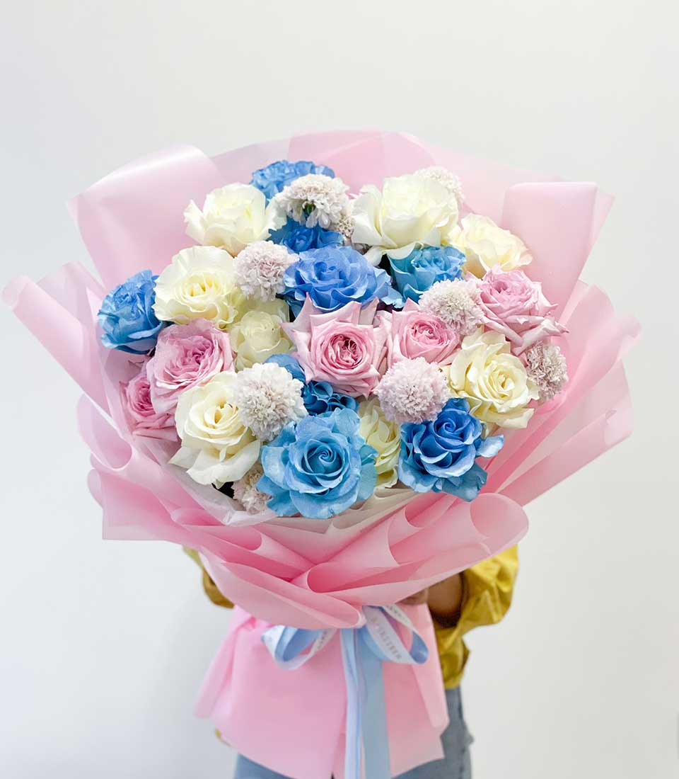 Pastel Dreams rose bouquet with blue, pink and white roses wrapped in pink paper with blue ribbon
