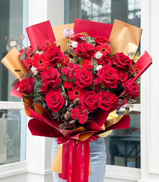 Luxe crimson rose and gerbera bouquet with gold gift wrap and red ribbon