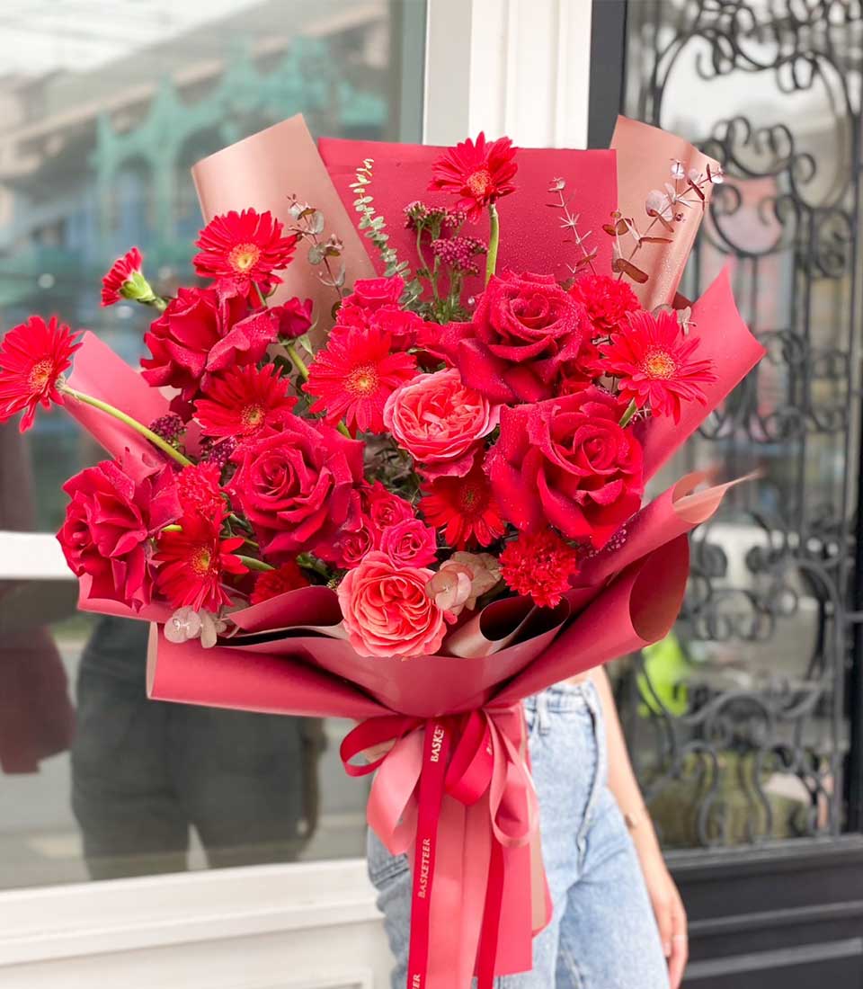 Ravishing red rose and gerbera daisy bouquet with layered red wrapping and ribbon