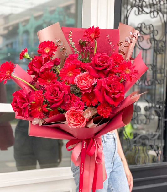 Ravishing red rose and gerbera daisy bouquet with layered red wrapping and ribbon