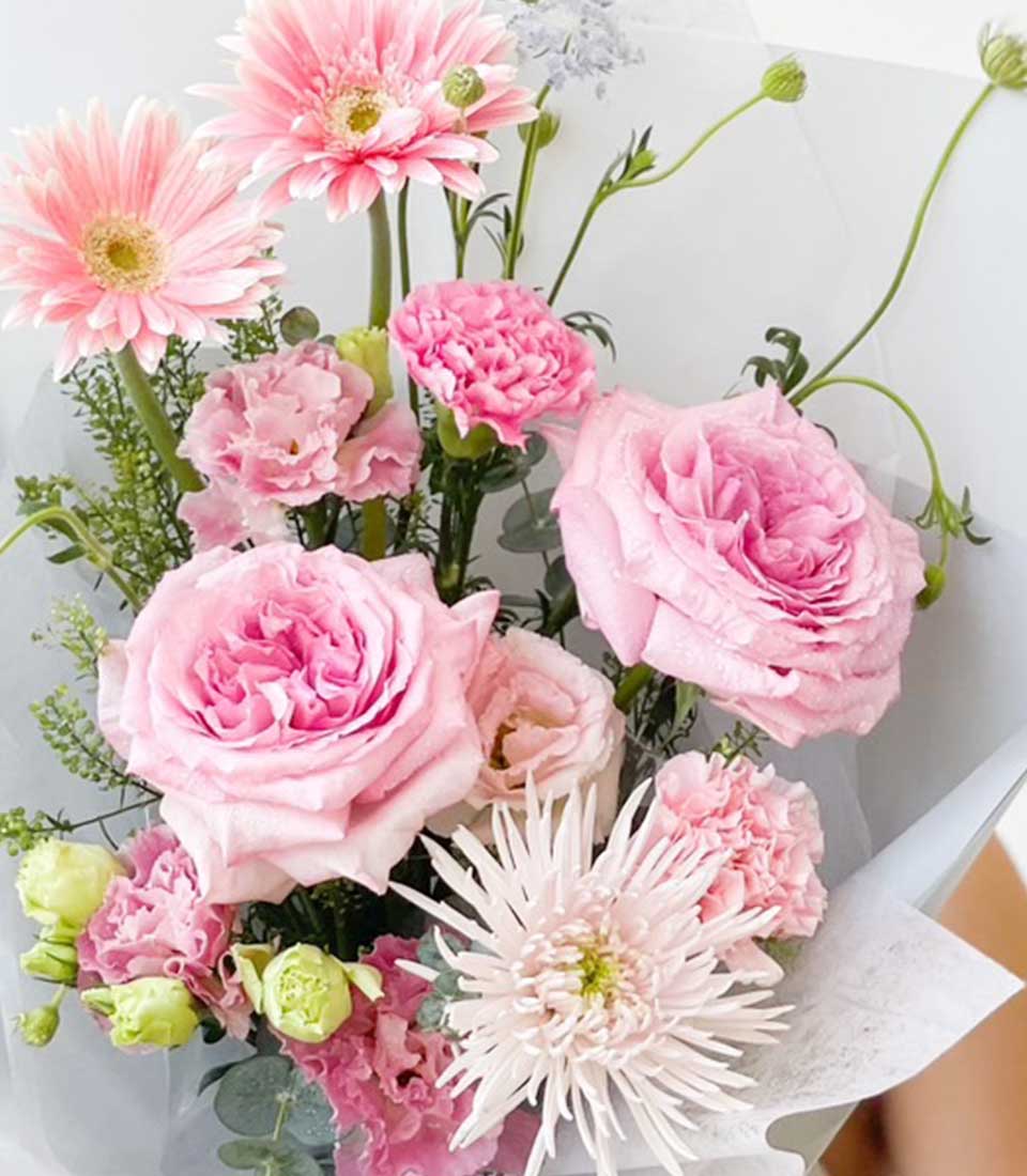 Pink and white fresh flower bouquet with roses, gerberas, and carnations for graduation celebrations
