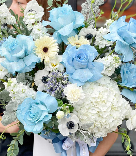 Light blue roses with white hydrangeas and anemones in elegant white hatbox gift arrangement