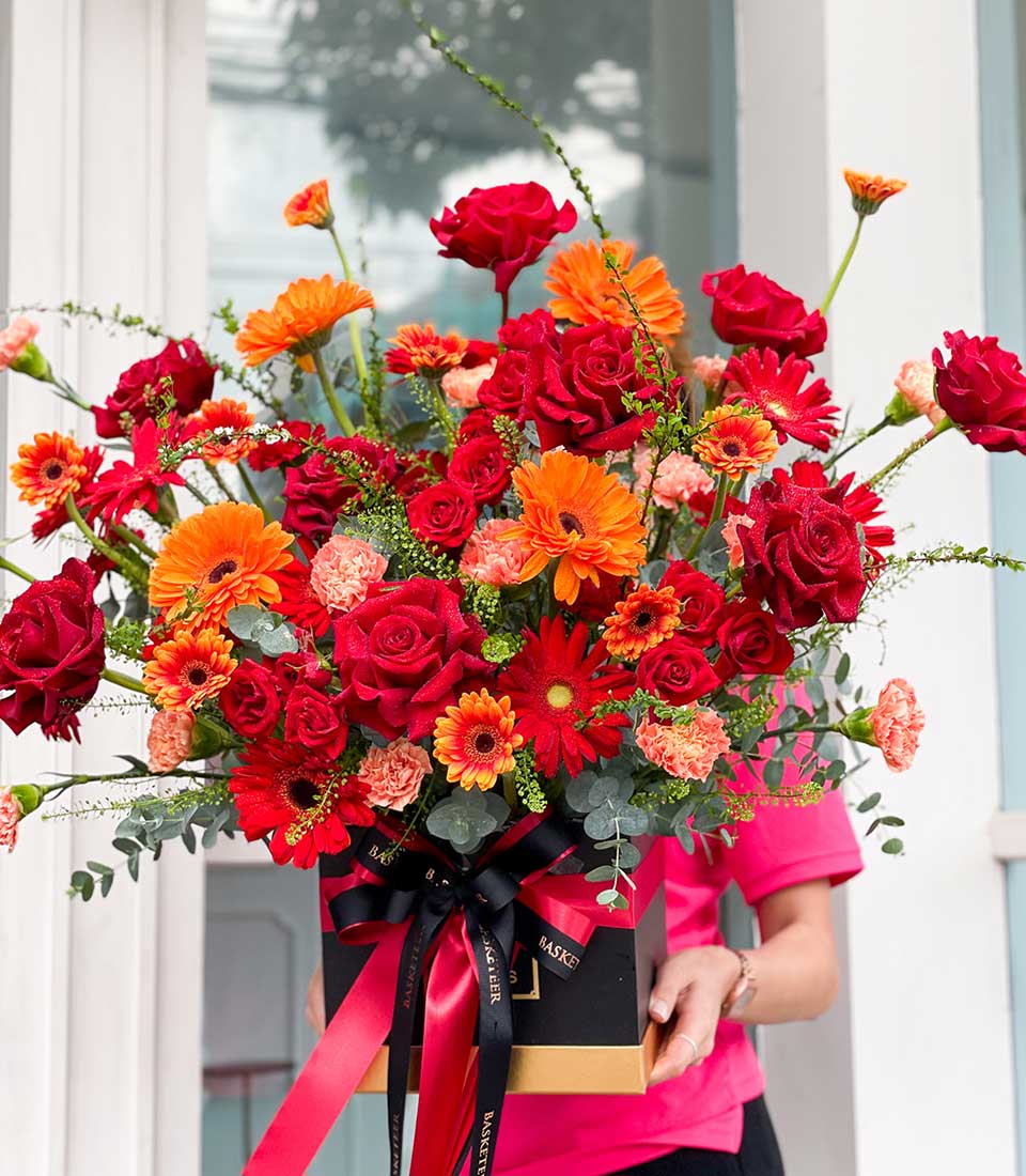 Scarlet Blooms luxury rose and gerbera arrangement in black and gold gift box with red satin ribbon