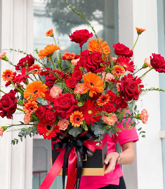 Scarlet Blooms luxury rose and gerbera arrangement in black and gold gift box with red satin ribbon