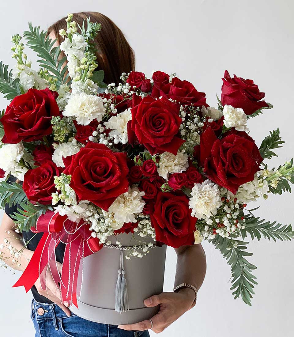 Red rose and white carnation graduation flowers in grey hatbox with satin ribbon