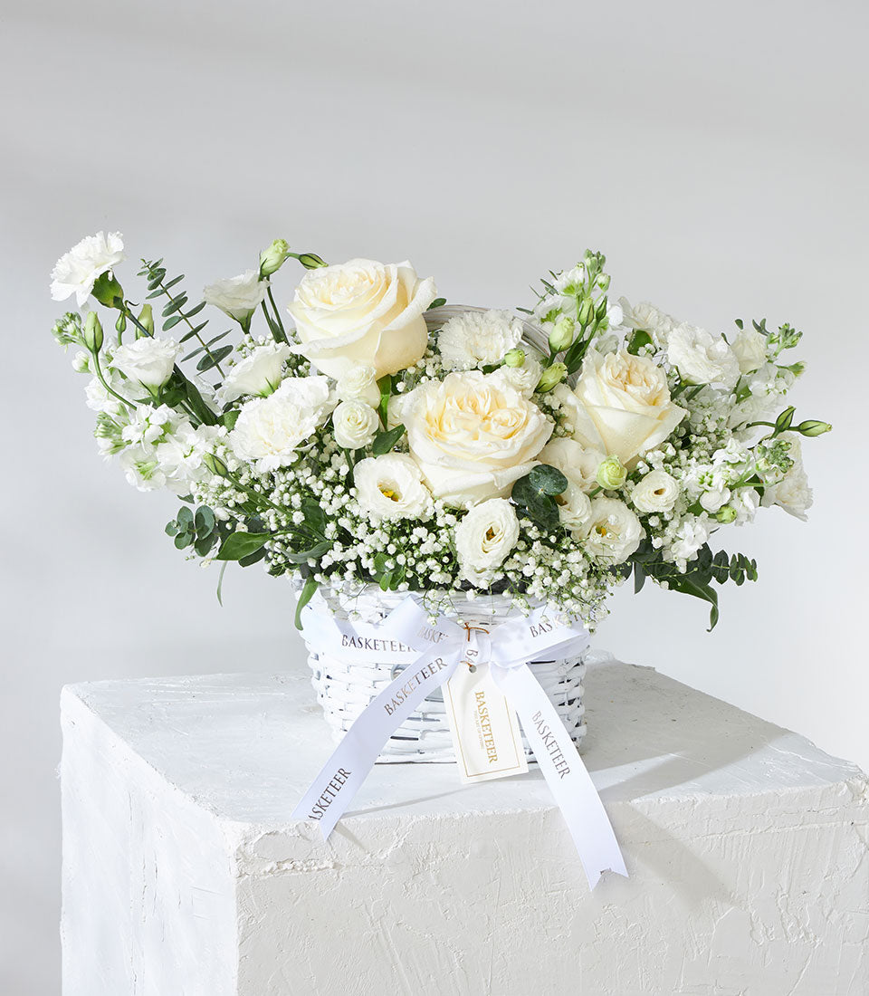 White and cream garden roses with baby's breath in woven basket, premium fresh flowers for gifting