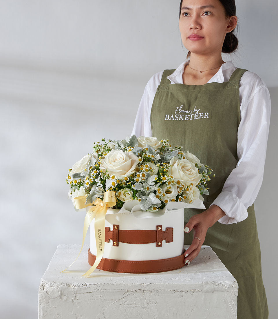 Premium white roses and daisy arrangement in luxury leather flower box with gold-buckle straps