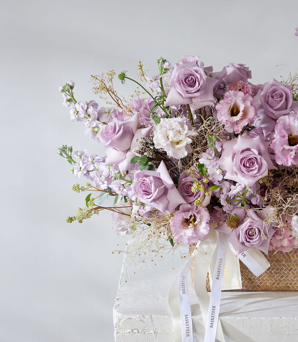 Lavender and white roses with hydrangea in premium woven basket, fresh flower arrangement with satin ribbon accents