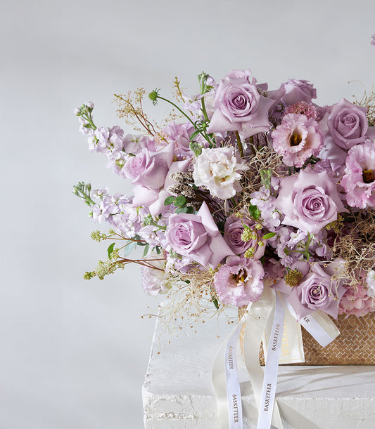 Lavender and white roses with hydrangea in premium woven basket, fresh flower arrangement with satin ribbon accents