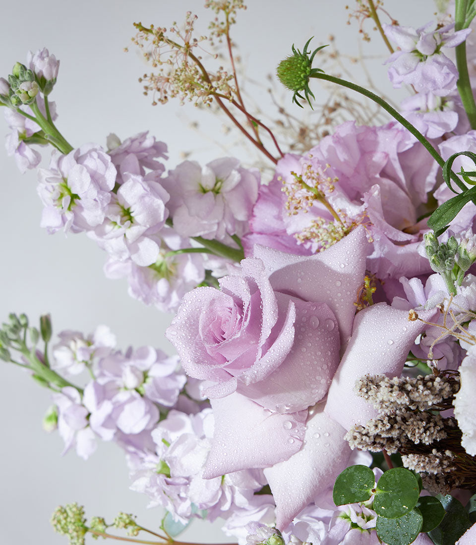 Lavender roses and hydrangea fresh flower basket with dewy petals and purple blooms