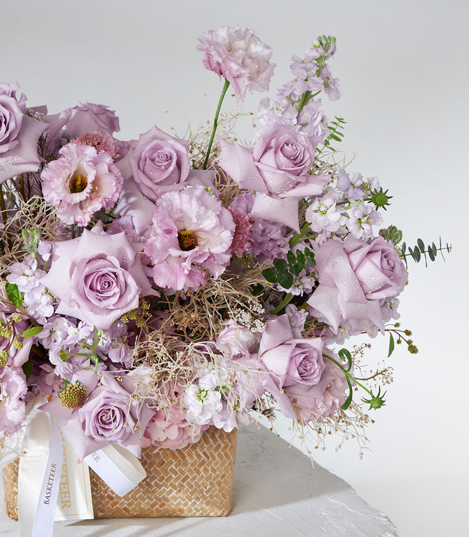 Lavender roses and hydrangea fresh flower basket with dried elements and white ribbon