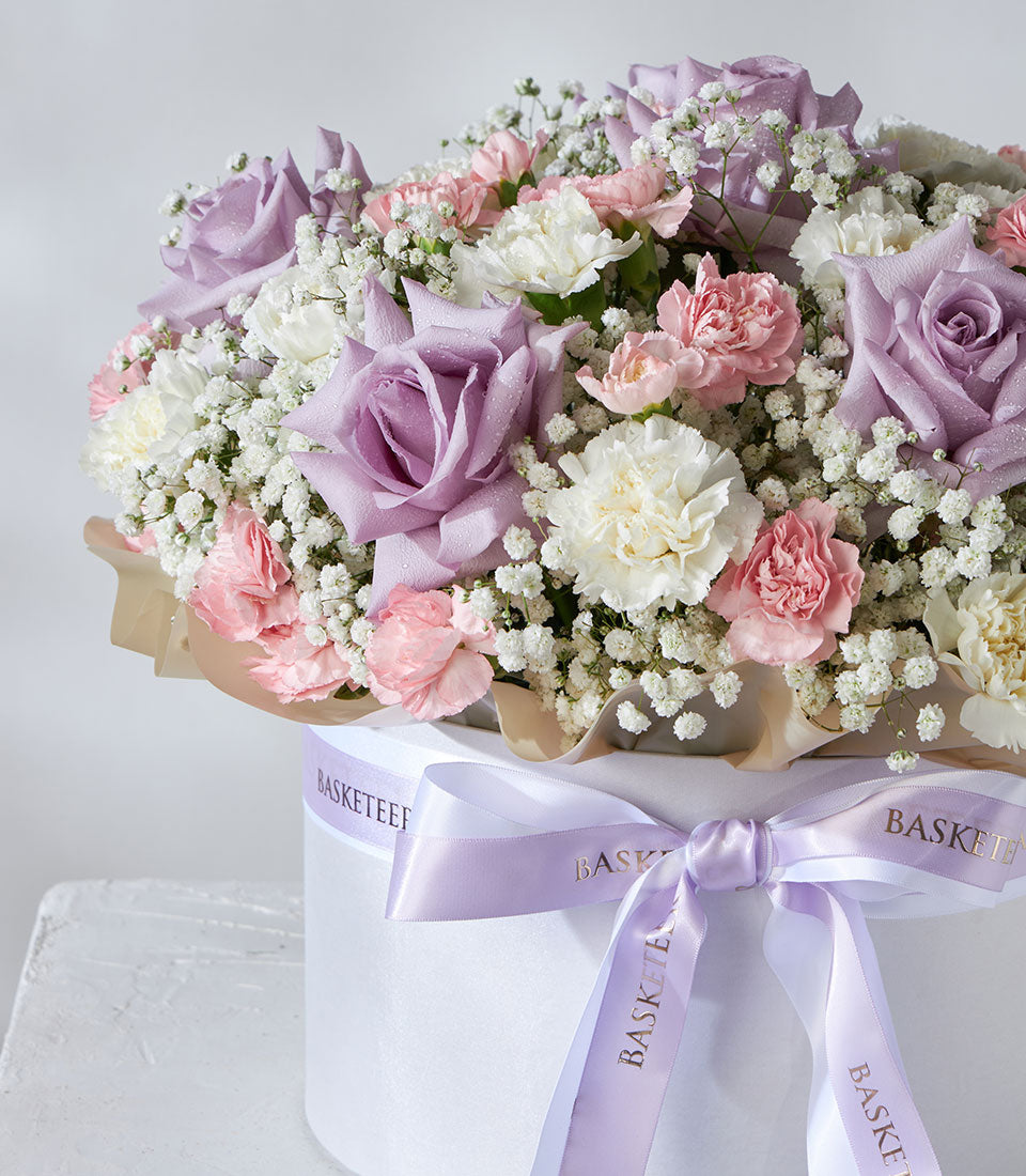 Lavender roses and pastel carnations in white luxury flower box with satin ribbon