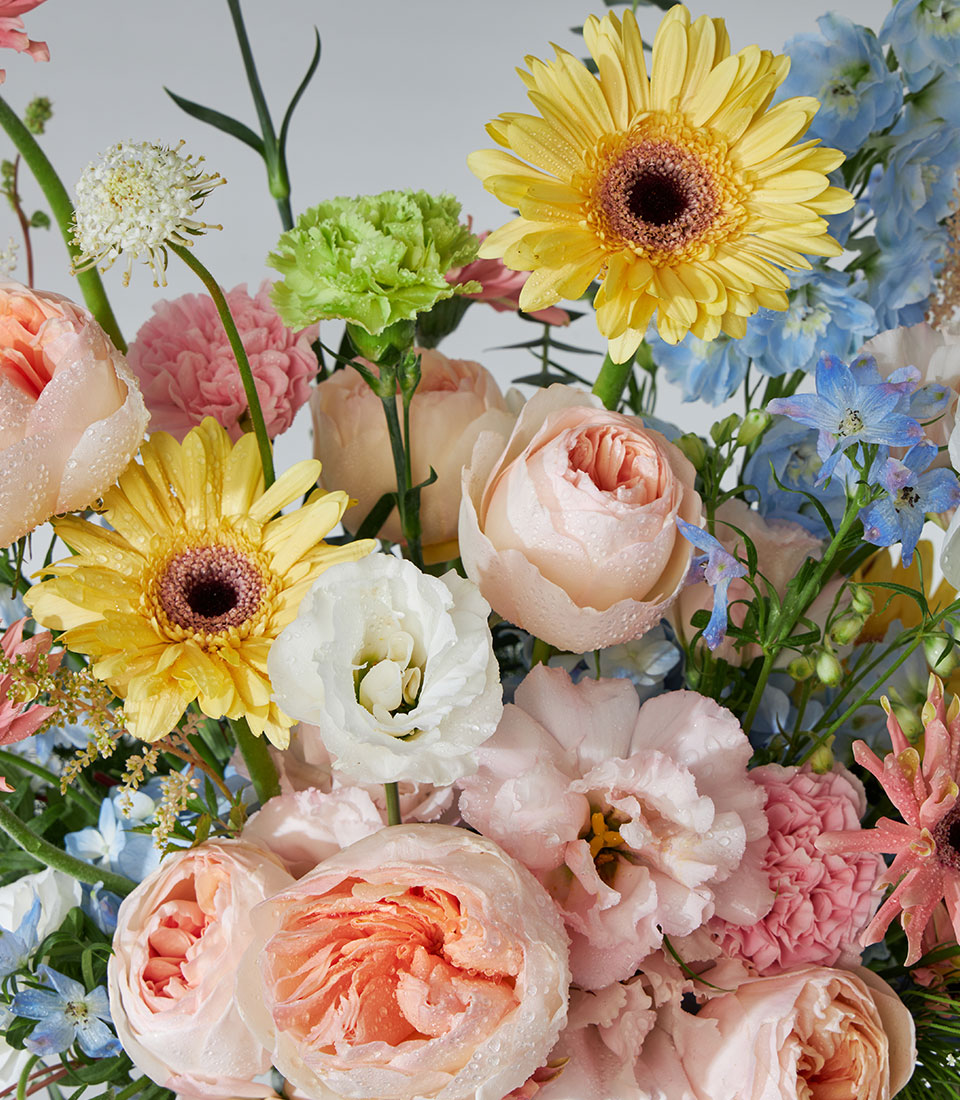 Juliet roses and pastel garden flowers with yellow gerberas in ceramic vase