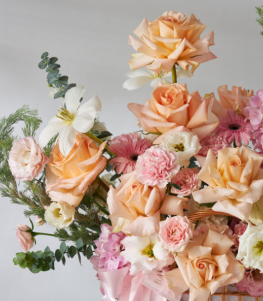 Premium pink roses and peach hydrangea arrangement in woven basket with eucalyptus greenery