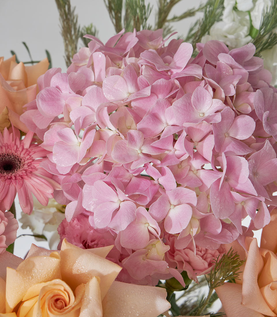 Tiffany roses and pink hydrangea bouquet with peach tones in premium flower basket arrangement