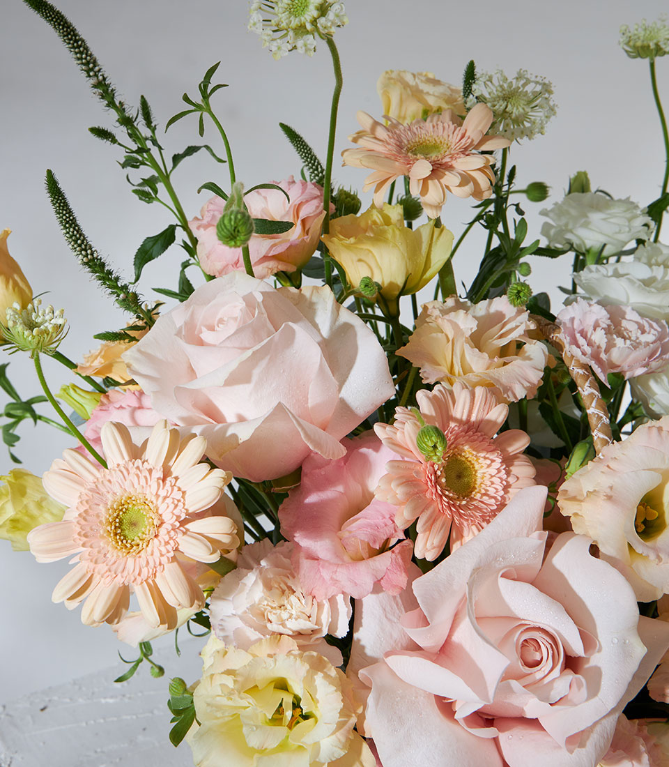 Pastel pink and white rose flower basket with gerbera daisies and lisianthus, perfect for birthday celebrations