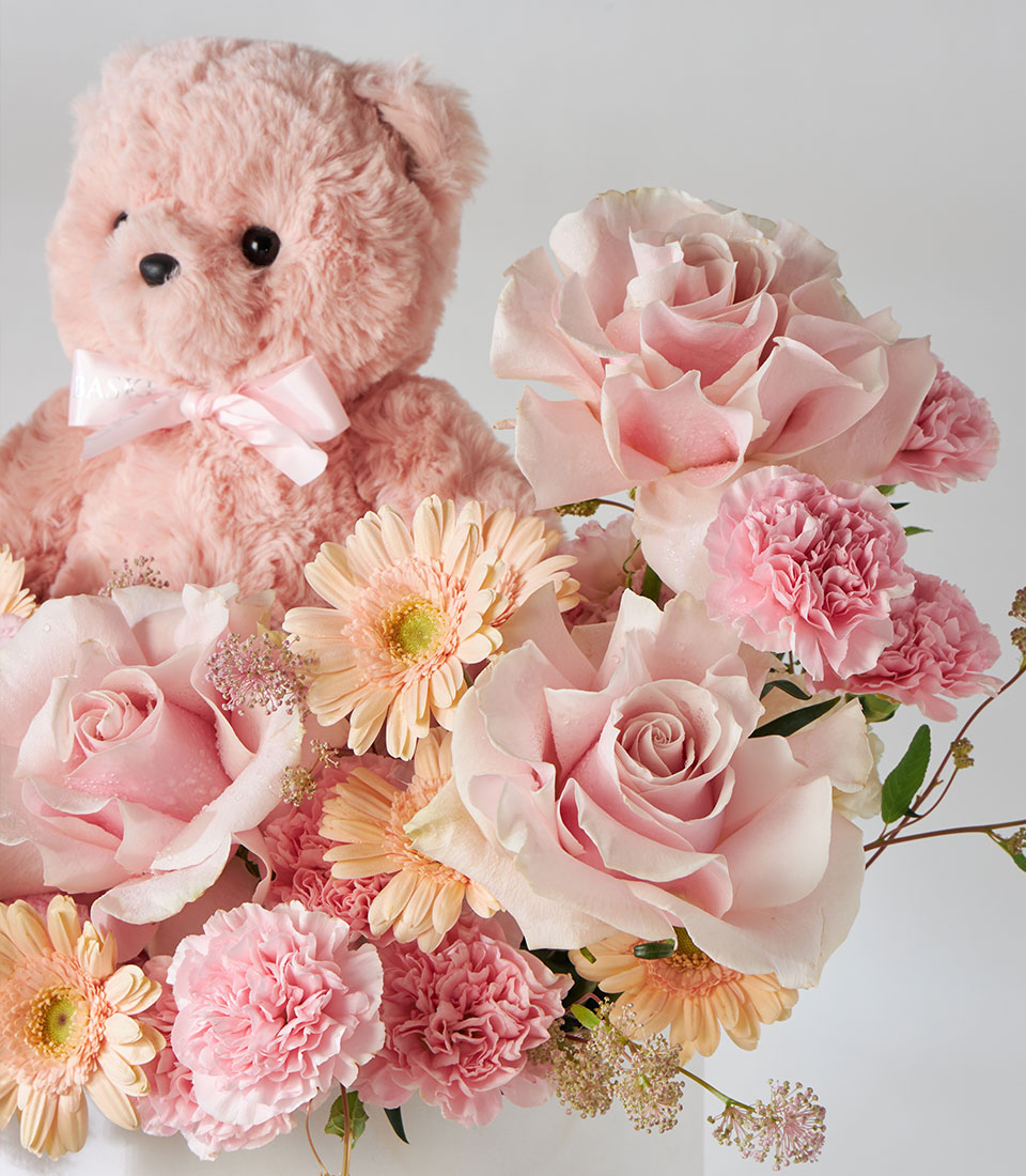 Pink Mondial roses, carnations, and gerbera daisies with blush teddy bear in premium flower box for birthdays and